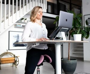 Woman sitting on an ergonomic work chair and working in home office